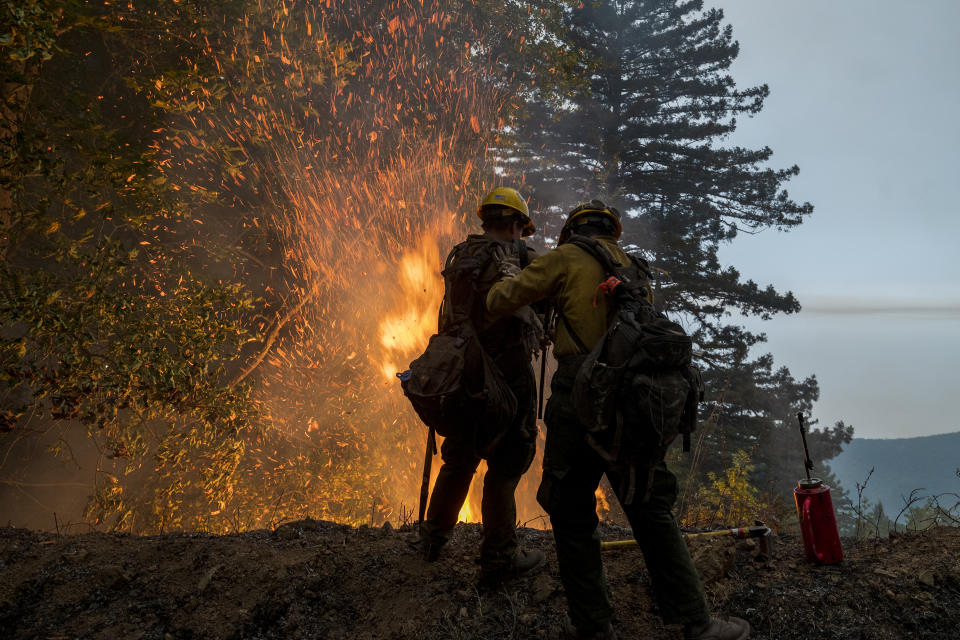 Firefighters monitor a controlled burn along Nacimiento-Fergusson Road to help contain the Dolan Fire near Big Sur, Calif., Friday, Sept. 11, 2020. (AP Photo/Nic Coury)