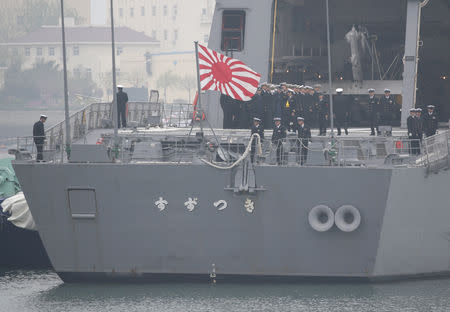 A Japanese military flag is seen at the back of the Japan Maritime Self-Defense Force destroyer JS Suzutsuki (DD 117) as it arrives at Qingdao Port for the 70th anniversary celebrations of the founding of the Chinese People's Liberation Army Navy (PLAN), in Qingdao, China, April 21, 2019. REUTERS/Jason Lee