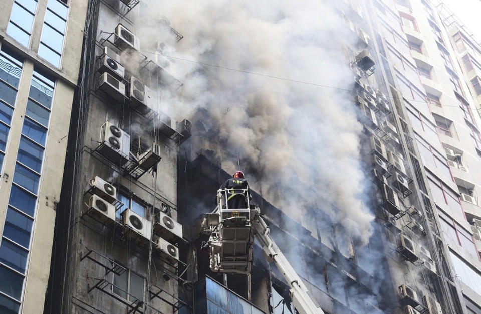 FILE - In this March 28, 2019, file photo, a firefighter works to douse a fire in a multi-storied office building in Dhaka, Bangladesh. The fire in Banani, a busy upscale commercial district, exposed the vulnerabilities hidden behind the glass towers that have become symbols of Bangladesh’s rapid growth. While Bangladesh’s economy has expanded by more than 6 percent annually in the last decade, safety regulations and enforcement have lagged behind, experts say. (AP Photo/Mahmud Hossain Opu, File)