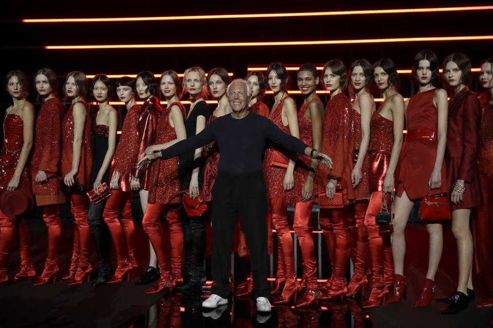 Designer Giorgio Armani, centre, poses with models after the Emporio Armani women's Fall-Winter 2019-2020 collection, that was presented in Milan, Italy, Thursday, Feb.21, 2019. (AP Photo/Luca Bruno)