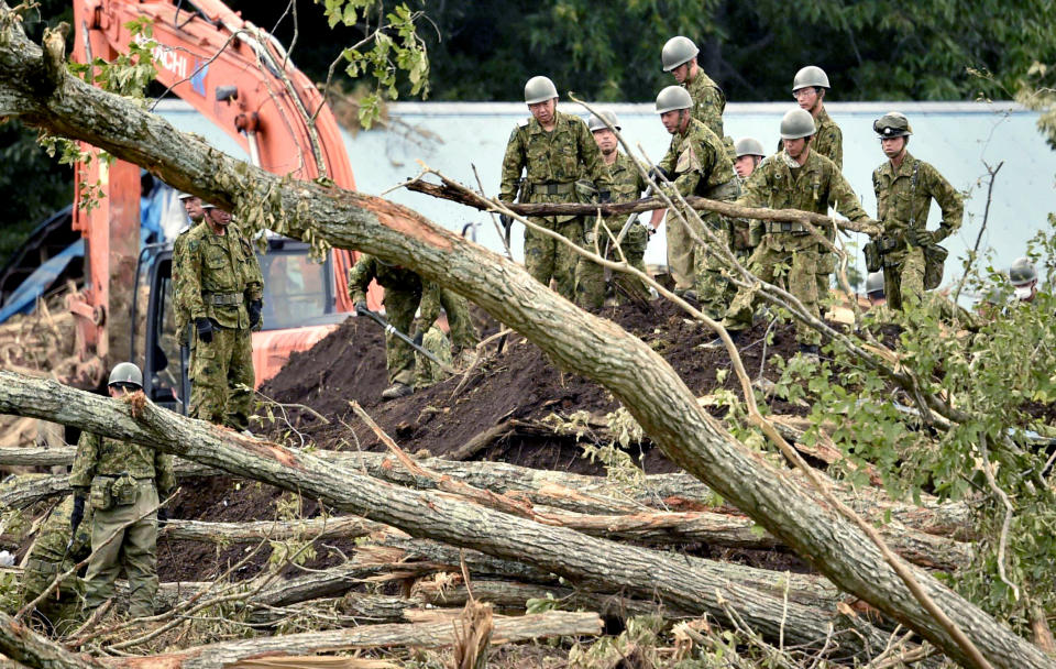 Japan's Self-Defense Force members work at the site of a landslide triggered by Thursday's earthquake in Atsuma, Hokkaido, northern Japan Sunday, Sept. 9, 2018. Japanese authorities say dozens of people have been confirmed dead from a powerful earthquake that struck the northern island of Hokkaido last week. (Yu Nakajima/Kyodo News via AP)