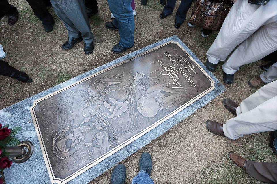 People view the grave marker of country music star George Jones after it was unveiled along with a monument Monday, Nov. 18, 2013, in Nashville, Tenn. Jones died April 26. (AP Photo/Mark Humphrey)
