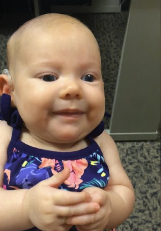 The three-month-old smiles when she realises she can hear her mother's voice. Credit: Caters