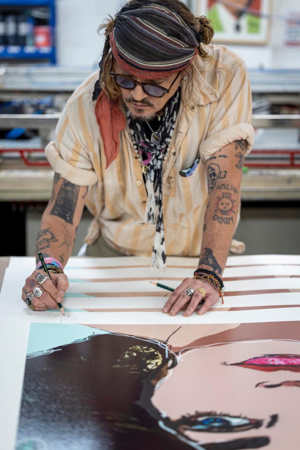 Depp pictured signing the limited-edition artwork (Castle Fine Art)