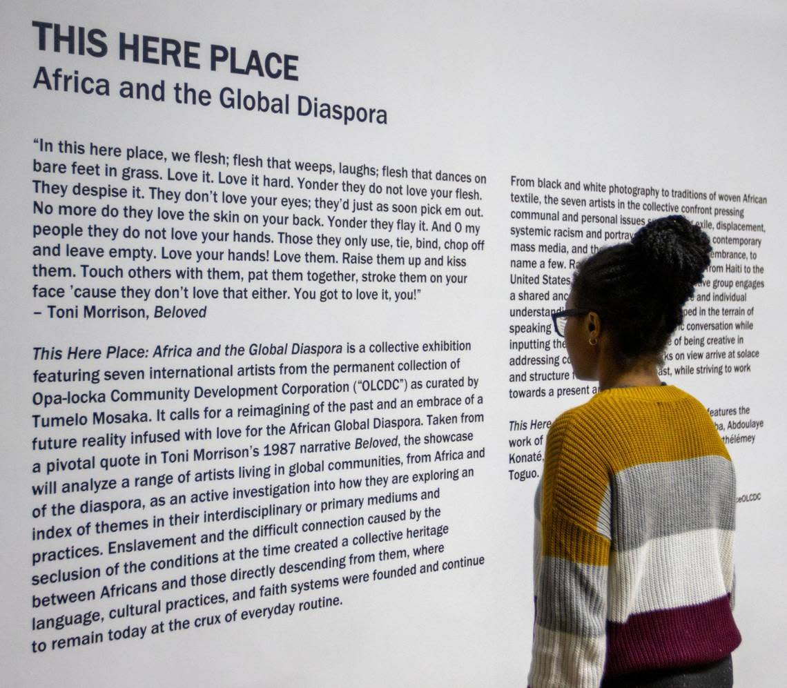 A woman reads the artist statement during the Preview for The Art of Transformation event.