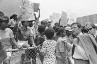 File - In this May 21, 1970, file photo, U.S. Sen. Birch Bayh, D-Ind., right, passes demonstrators protesting the slaying of two African Americans on the campus of Jackson State College, in Jackson, Miss. Sen. Bayh and several other congressmen inspected the site where two men died and 12 people were wounded as white lawmen shot indiscriminately, riddling the windows of a women's dormitory as officers claimed they had seen a sniper. The historically Black school canceled its 1970 commencement after the incident. Fifty-one years later, the school now called Jackson State University is honoring its Class of 1970, as members are being invited back to salute their academic achievements with a graduation ceremony. Saturday, May 15, 2021. (AP Photo, File)