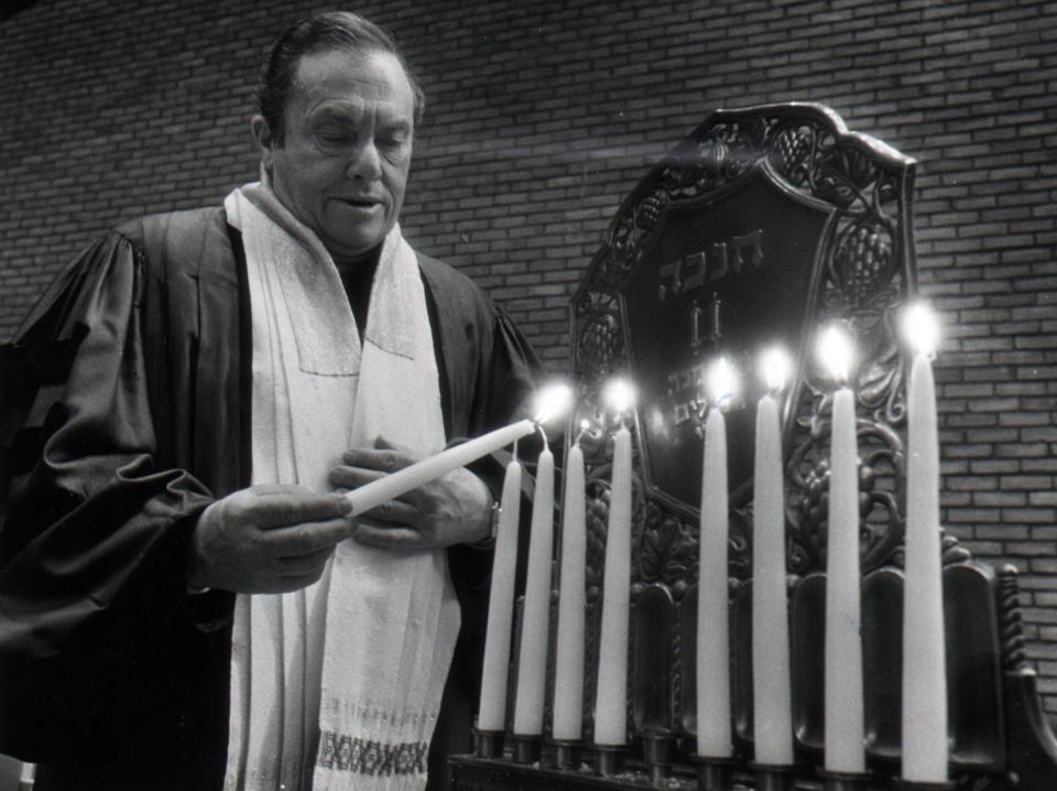 Rabbi Albert A. Goldman of Isaac M. Wise Temple lights the eight candles of the menorah in 1979.