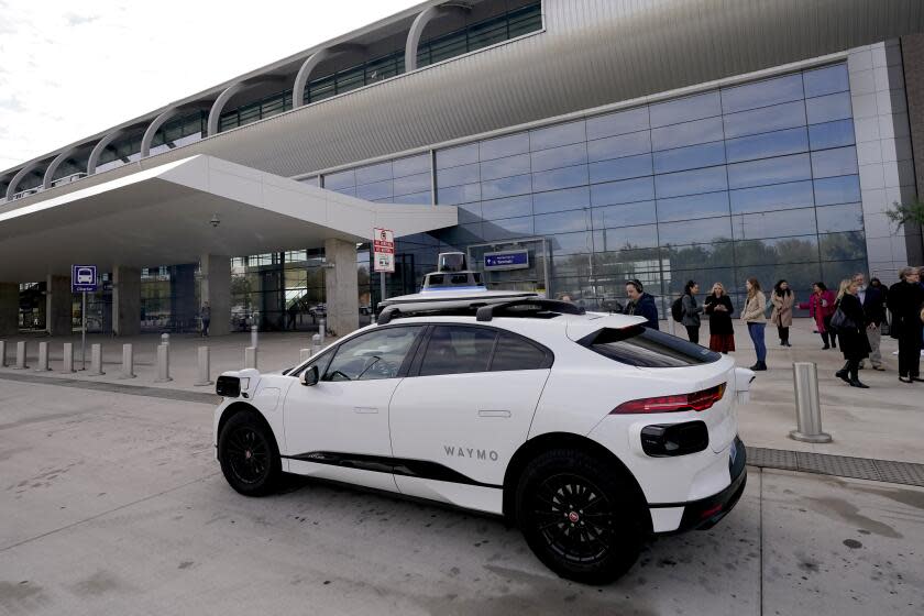 A Waymo self-driving vehicle sits curbside, Friday, Dec. 16, 2022, at the Sky Harbor International Airport Sky Train facility in Phoenix. Phoenix Mayor Kate Gallego announced Friday that Sky Harbor will be the first airport to have self-driving, ride-hailing service Waymo available. A test group has been using Waymo vehicles from the airport's sky train to downtown Phoenix since early November.(AP Photo/Matt York)