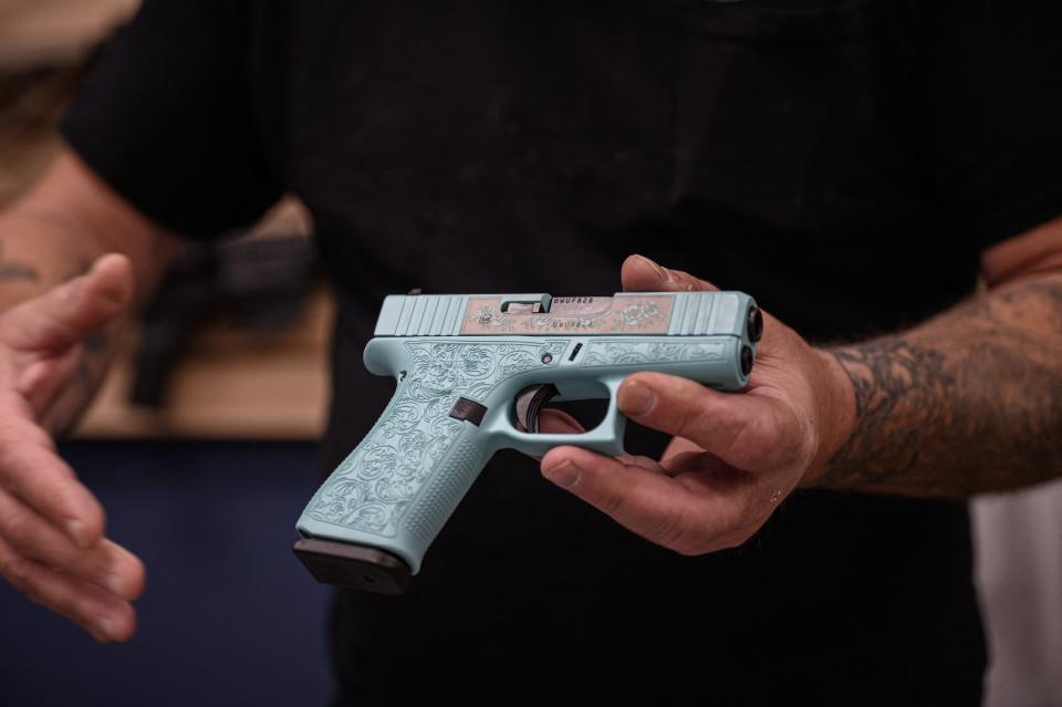 Gun-maker and business-owner Tony Hook of RTD Arms & Sport in Goffstown, New Hampshire holds a customized Glock pistol at his shop on June 2, 2022.