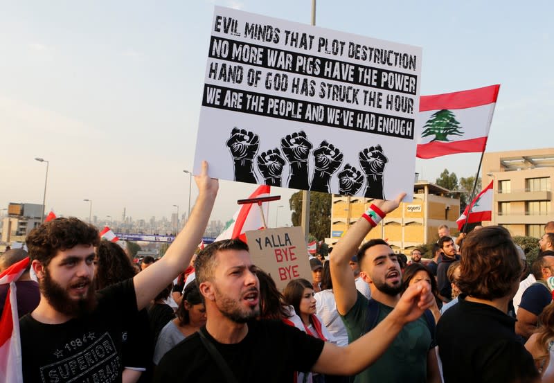 Demonstrators hold banners and chant slogans during ongoing anti-government protests in Hazmiyeh