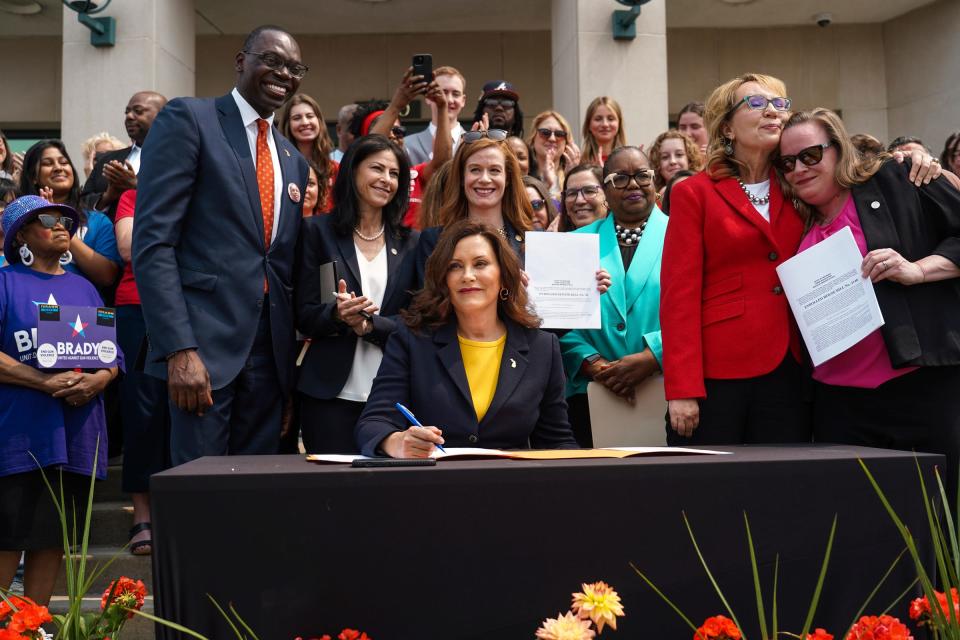 Michigan Gov. Gretchen Whitmer poses with officials after she signs into law bills that would allow police officers, family members and medical professionals to ask courts to issue an extreme risk protection order to temporarily take away guns from those who pose a danger to themselves or others on Monday, May 22, 2023, outside of the 44th District Court in Royal Oak.