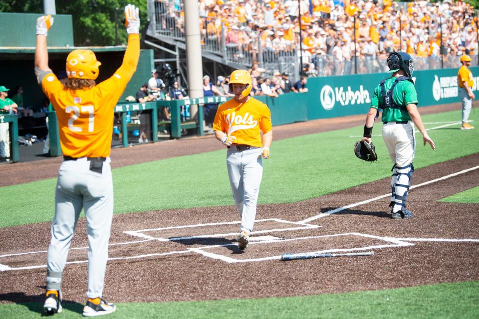 Tennessee's Jordan Beck (27) raises his arms as Tennessee's Seth Stephenson (4) runs into home during game two of the NCAA Baseball Tournament Knoxville Super Regional between the Tennessee Volunteers and the Notre Dame Irish held at Lindsey Nelson Stadium on Saturday, June 11, 2022. 