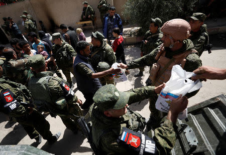 People who fled eastern Ghouta receive aid from Russian forces at a shelter in Adra, near Damascus, Syria, March 20, 2018. REUTERS/Omar Sanadiki