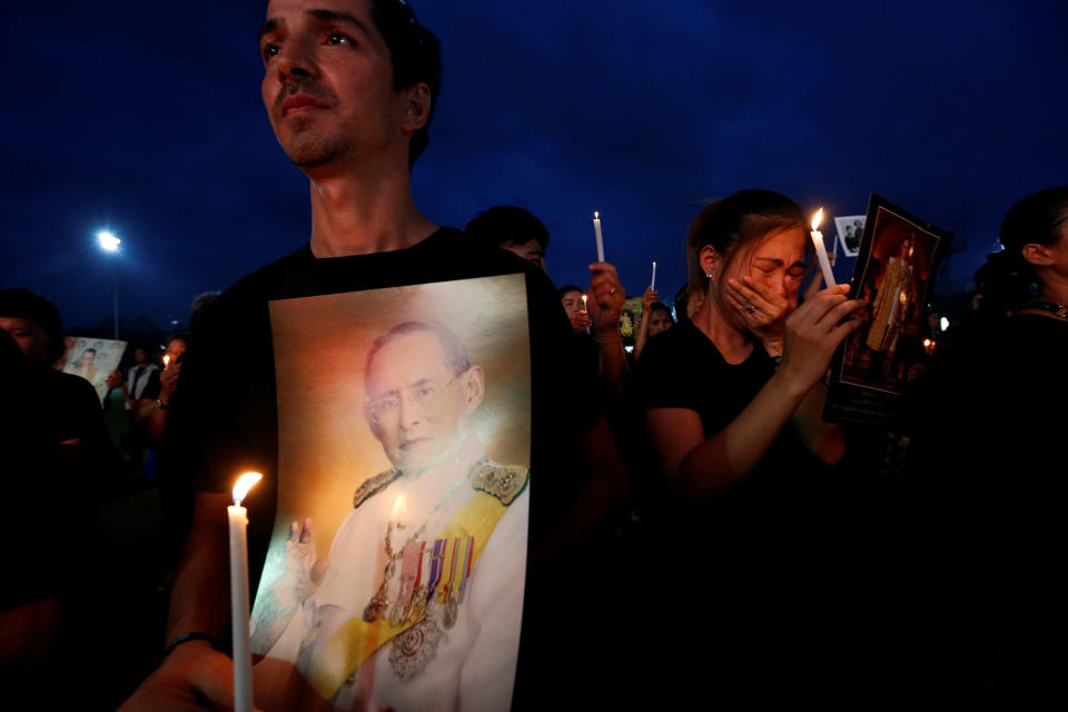 Mourners hold up pictures of Thailand’s late King Bhumibol Adulyadej in Bangkok