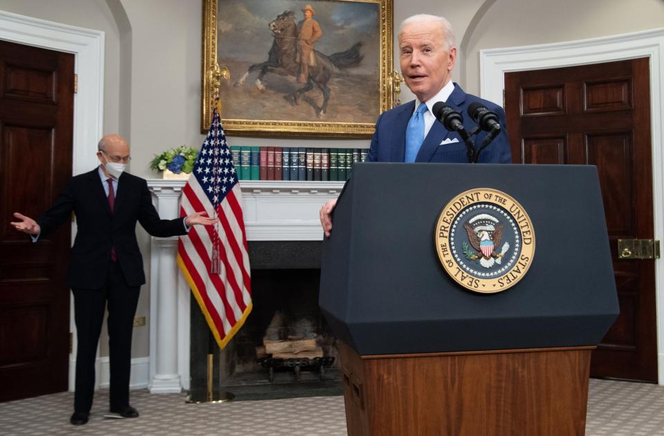 President Biden stands at a lectern; Justice Stephen Breyer stands in the background.