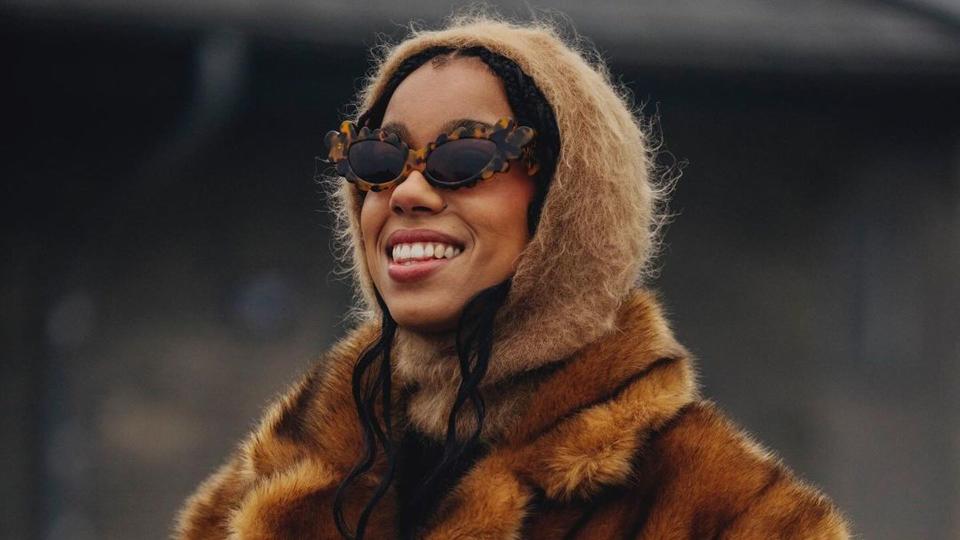 @amaka.hamelijnck wears a fur coat, hood and sunglasses while in Copenhagen for fashion week