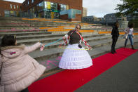 Antoinette van Zalinge, principal of the public elementary school De Notenkraker, who dressed up to show the need of social distancing, welcomes pupils in Amsterdam, Monday, May 11, 2020, as primary schools, barber shops and libraries reopened after a partial lockdown because of the outbreak of the COVID-19 coronavirus. (AP Photo/Peter Dejong)