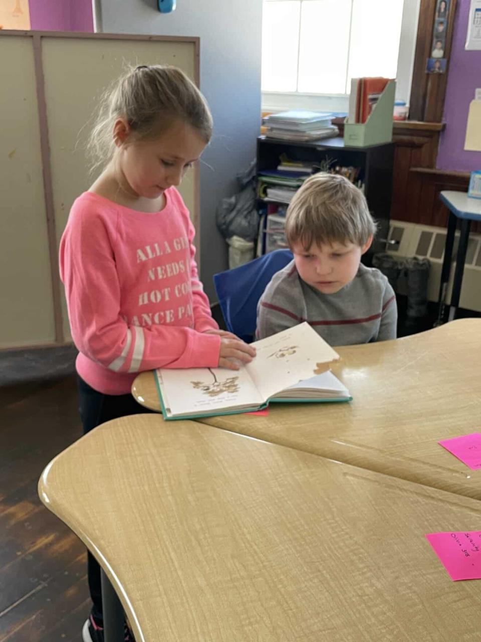 Second-grader Bella Bentley (left) and fourth-grader Bry Post-Flood (right) read together to celebrate Read Across America and Dr. Seuss Day.