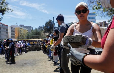 People clean debris from the streets in the aftermath of the last days' protests in Quito