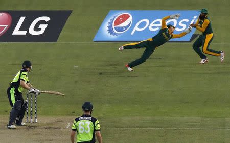 Ireland's Niall O'Brien (L) watches as South Africa's wicketkeeper Quinton de Kock (2nd R) dives and Hashim Amla (R) takes a catch under his arm to dismiss him for 14 runs during their Cricket World Cup match at Manuka Oval in Canberra March 3, 2015. REUTERS/Jason Reed