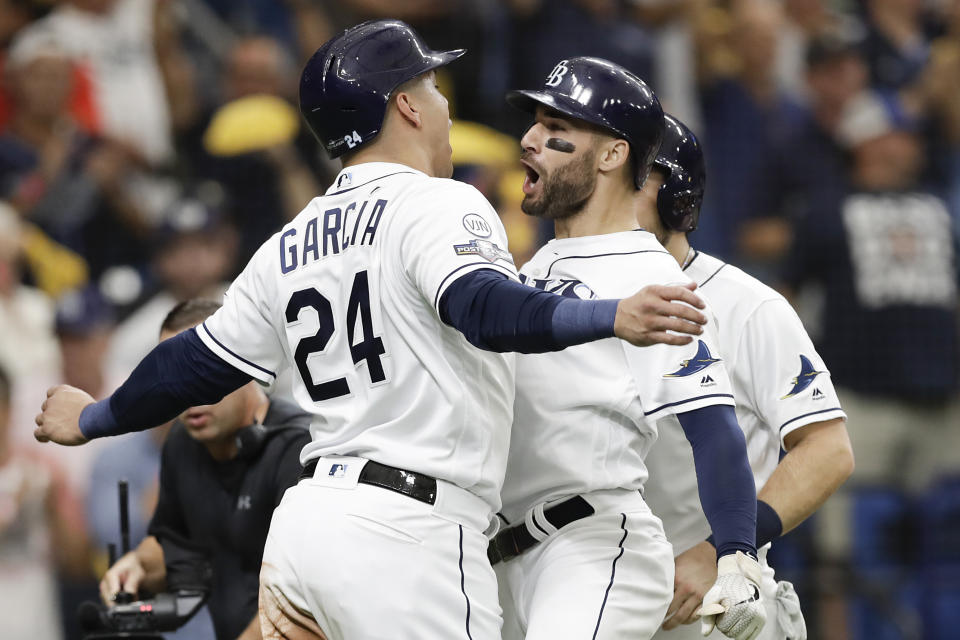 Kevin Kiermaier festeja con el venezolano Avisaíl García, su compañero en los Rays de Tampa Bay, luego de conectar un jonrón de tres carreras ante los Astros de Houston en el tercer juego de la Serie Divisional de la Liga Americana, el lunes 7 de octubre de 2019 (AP Foto/Chris O'Meara)