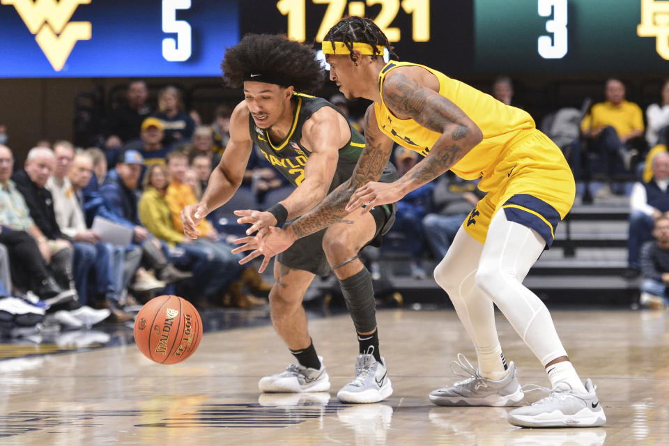 West Virginia forward Jalen Bridges (11) steals the ball from Baylor guard Kendall Brown (2) during the first half of an NCAA college basketball game in Morgantown, W.Va., Tuesday, Jan. 18, 2022. (William Wotring)