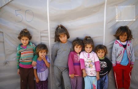 Kurdish refugee children from the Syrian town of Kobani stand near a makeshift tent in a camp in the southeastern town of Suruc, Sanliurfa province October 26, 2014. REUTERS/Kai Pfaffenbach