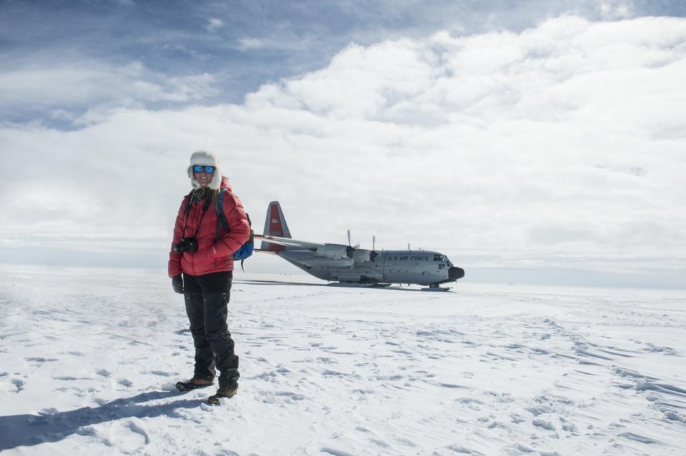 Maggie Shipstead stands before a cargo plane in the snow.