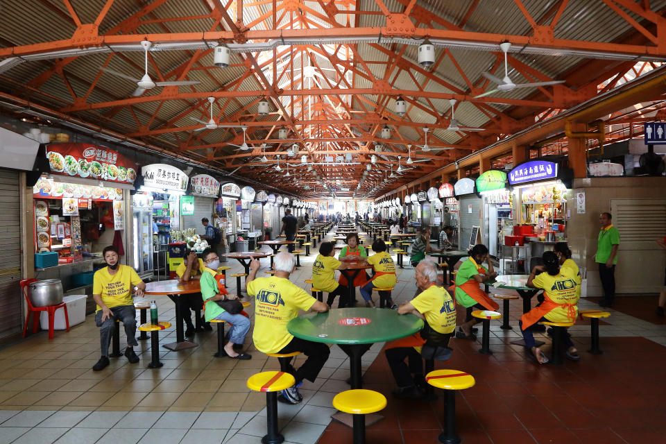 SINGAPORE - APRIL 07: Tables tray cleaners are seen mingling at a hawker centre on April 7, 2020 in Singapore. Singapore government starts closing non-essential workplaces and schools temporarily for a month from today, April 7 to contain the spread of the COVID-19 infections.  (Photo by Suhaimi Abdullah/Getty Images)