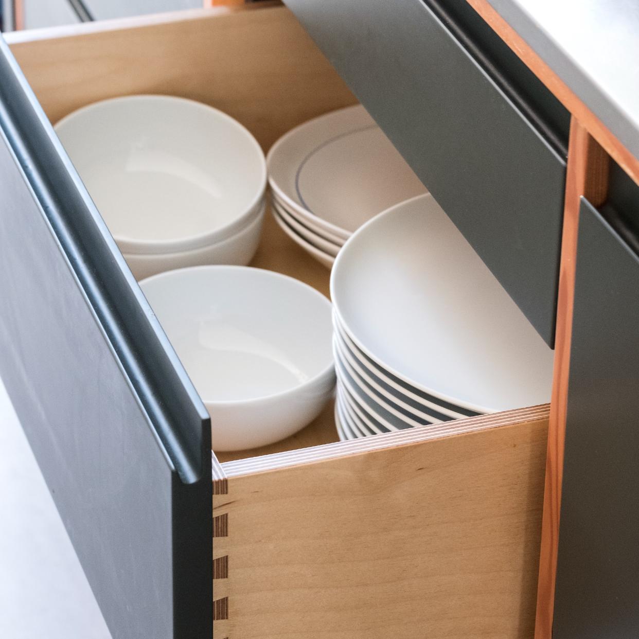  A kitchen drawer full of white ceramic tableware. 