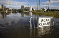A road closed sign tells motorist to not pass through the flood waters at the intersection of Fishburne St. and Hagood Ave. as a king tide rolls into historic Charleston, S.C. Sunday, Nov. 15, 2020. Charleston has remained relatively unscathed this hurricane season. That means more time to mull a $1.75 billion proposal by the Army Corps of Engineers that features a sea wall along the city's peninsula to protect it from deadly storm surge during hurricanes. (AP Photo/Mic Smith)