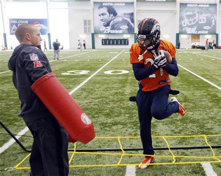 Denver Broncos running back Knowshon Moreno (R) runs a drill as an assistant stands by during their practice session for the Super Bowl at the New York Jets Training Center in Florham Park, New Jersey January 30, 2014. REUTERS/Ray Stubblebine