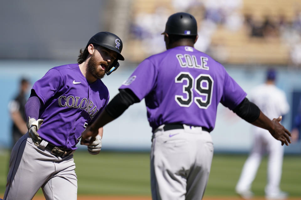 Colorado Rockies' Brendan Rodgers, left, celebrates with third base coach Stu Cole after his solo home run during the first inning of a baseball game against the Los Angeles Dodgers, Sunday, Oct. 2, 2022, in Los Angeles. (AP Photo/Marcio Jose Sanchez)