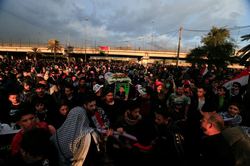 Mourners carry a mock coffin for an Iraqi demonstrator, who was killed during ongoing anti-government protests, at a symbolic funeral in Baghdad