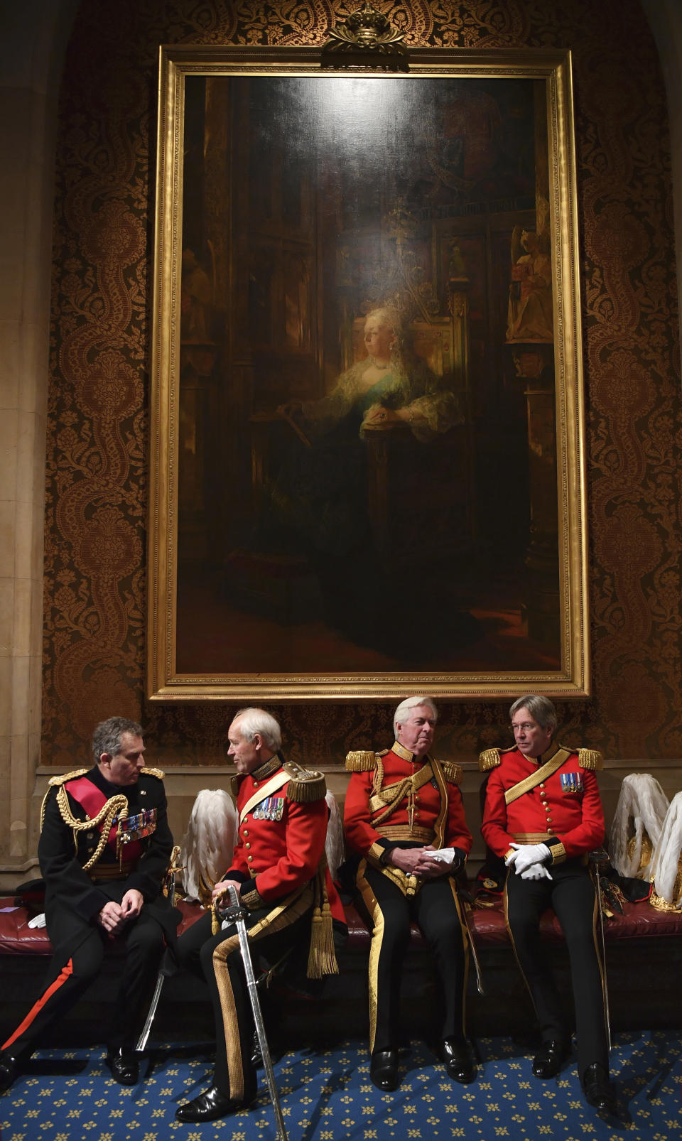 Gentlemen at Arms relax and prepare for the arrival of the Queen at the Norman Porch during the State Opening of Parliament at the Houses of Parliament in London, Thursday, Dec. 19, 2019. Queen Elizabeth II will formally open a new session of Britain's Parliament on Thursday, with a speech giving the first concrete details of what Prime Minister Boris Johnson plans to do with his commanding House of Commons majority. (Ben Stansall/Pool Photo via AP)