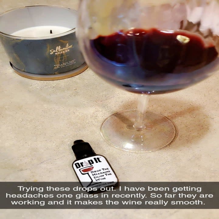 a glass of wine and the dropper bottle with text reading 