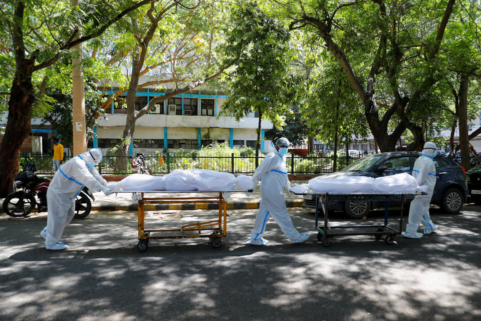 Image: Health workers carry bodies of people who were suffering from Covid-19 outside the Guru Teg Bahadur hospital in New Delhi, (Adnan Abidi / Reuters)