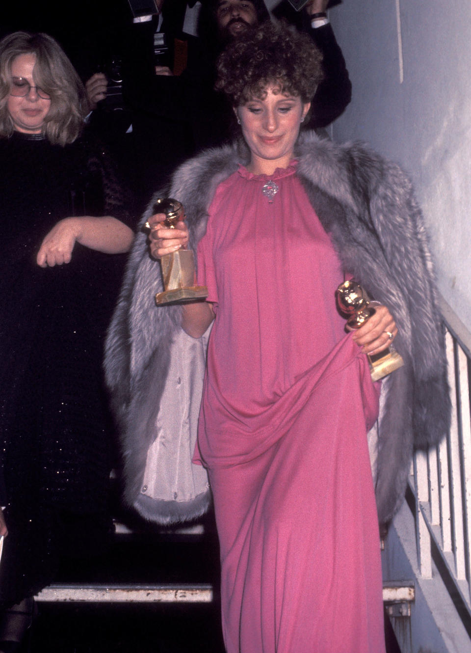 Barbra walking down the stairs holding awards