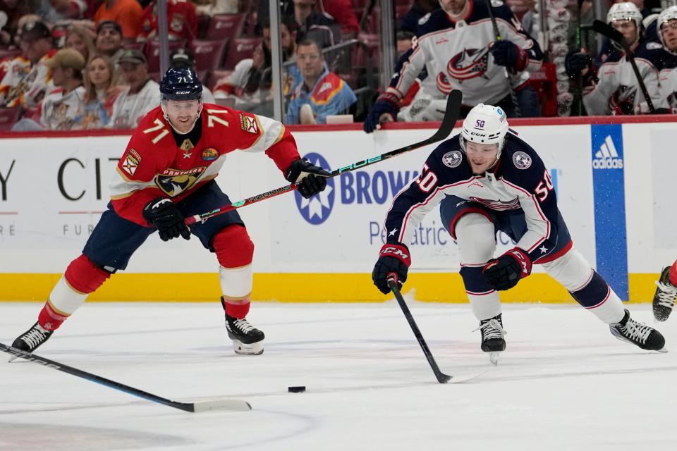 Florida Panthers center Chris Tierney (71) and Columbus Blue Jackets left wing Eric Robinson (50) go for the puck during the first period of an NHL hockey game, Tuesday, Dec. 13, 2022, in Sunrise, Fla. (AP Photo/Lynne Sladky)