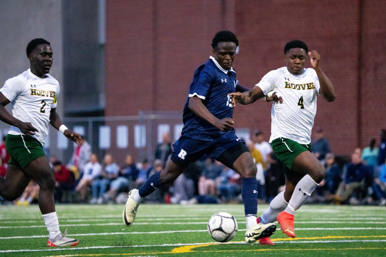 Roosevelt's Ephraim Lunganga takes the ball down the field for a goal against Hoover's Maxim Bebanga (4) and Charles Matalatala (2) Monday, May 6, 2024, at Theodore Roosevelt High School in Des Moines.