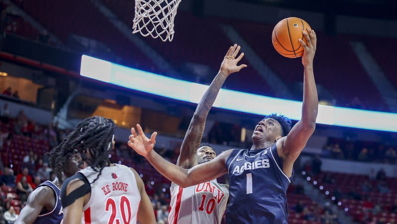 Utah State forward Great Osobor (1) shoots over UNLV forward Kalib Boone (10) during the second half of an NCAA college basketball game Saturday, Jan. 13, 2024, in Las Vegas. (AP Photo/Ian Maule)