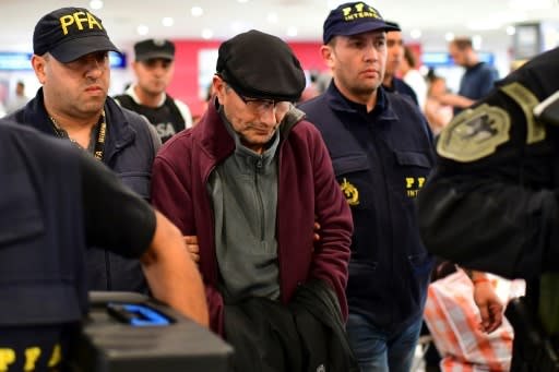 Mario Sandoval (C) is escorted by police officers at Buenos Aires' Ezeiza airport after being extradited from France to face trial over the 1976 disappearance of a student during Argentina's "dirty war"