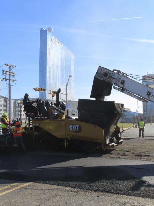 Heavy equipment repaves part of Atlantic Avenue in Atlantic City, N.J. on Dec. 13, 2023 as the city's controversial "road diet" project to narrow the main roadway from two lanes in each direction to one began. Five casinos and a hospital are asking a judge to order a halt to the plan, saying it could dangerously worsen traffic in the seaside gambling resort. (AP Photo/Wayne Parry)