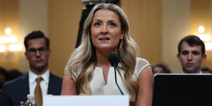 Sarah Matthews behind nameplate and microphone in commitee room