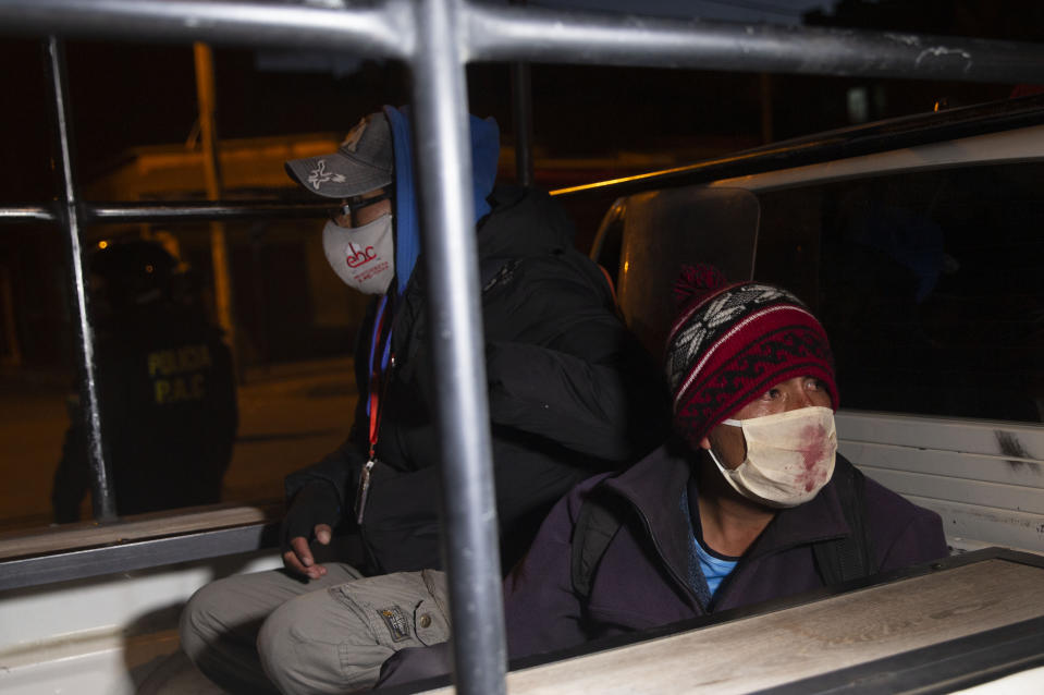 Detained demonstrators sit in the bed pf a police pick-up truck during a protest against the postponement of the upcoming presidential election in El Alto, Bolivia, Monday, Aug. 10, 2020. Citing the ongoing new coronavirus pandemic, the nation's highest electoral authority delayed presidential elections from Sept. 6 to Oct. 18, the third time the vote has been delayed. (AP Photo/Juan Karita)