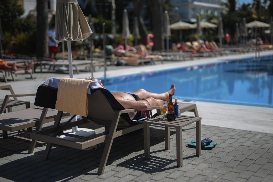 A German tourist takes a sunbath at the Riu Concordia hotel swimming pool in Palma de Mallorca, Spain, Monday, June 15, 2020. Whether its German holidaymakers basking in Spain's sunshine or Parisians renewing their love affair with their city, Monday's border openings and further scrapping of restrictions offered Europeans a taste of pre-coronavirus life that they may have taken for granted. (AP Photo/Joan Mateu)