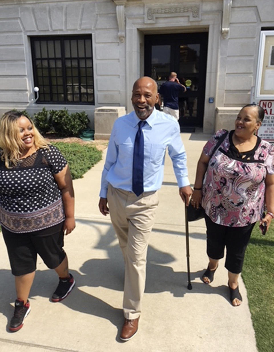 FILE - This photo provided by the Innocence Project shows Perry Lott, center, smiling as he leaves court in Oklahoma City, July 9, 2018, with his daughter Candace Brown, left, and Antoinette Brown, who was his fiancé at the time he was arrested, after being freed from prison when the Innocence Project presented DNA evidence it says excluded him from the crime. An Oklahoma judge on Tuesday, Oct. 10, 2023, exonerated Lott, who spent 30 years in prison for a 1987 rape and burglary, after post-conviction DNA testing from a rape kit showed he did not commit the crime. (Karen Thompson/Innocence Project via AP, File)