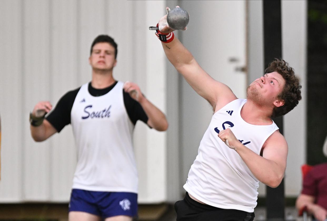 Bloomington South’s Ivan Lynch (left) cheers as Guy Drummond competes in the shot put during the track meet at North on Wednesday, May 1, 2024.