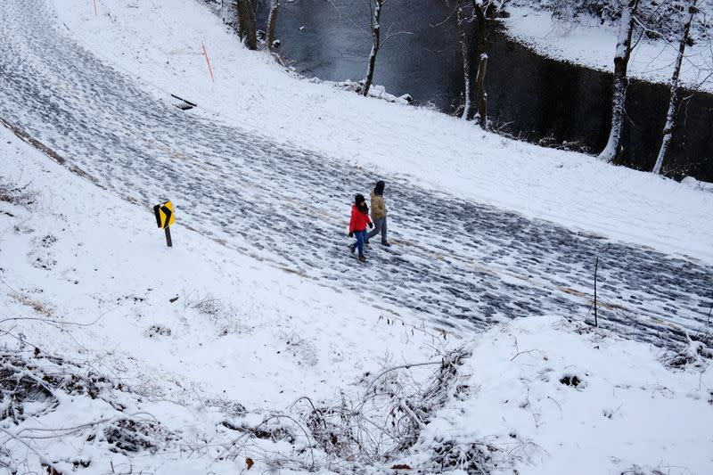 Local residents walks along a road in Rock Creek park after a snow storm in Washington, U.S.