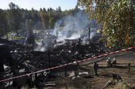 Russian Emergencies Ministry employees work amidst the debris of a psychiatric hospital destroyed by fire in the Novgorod region town of Luka September 13, 2013. The fire raged through the Russian psychiatric hospital on Friday, killing at least one person and leaving dozens missing as police searched the surrounding area for survivors, emergency and law enforcement officials said. (REUTERS/Lyudmila Popova)